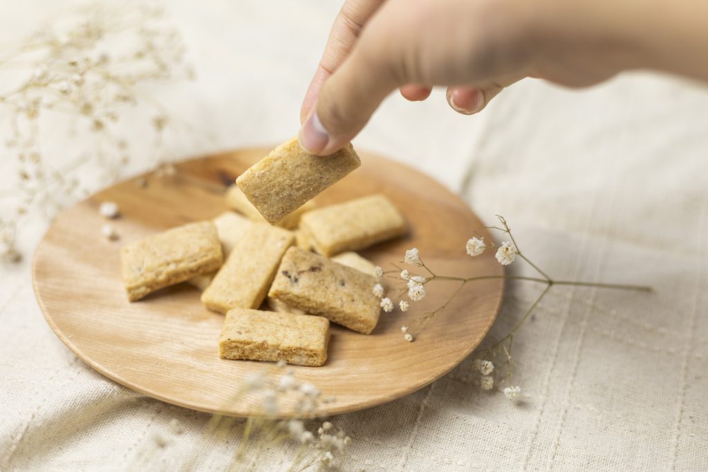 白川郷おからのまめなクッキーを手でつまんでいるところ